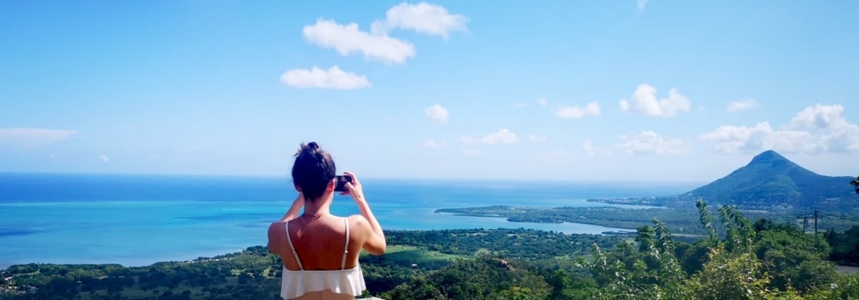 Une expatriée qui prend des photos du paysage en été à Maurice