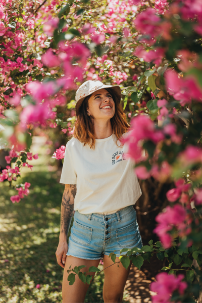 Charlotte, experte en voyage de repérage à Maurice Charlotte, spécialiste de l’expatriation, souriante au milieu de fleurs tropicales à l’Île Maurice