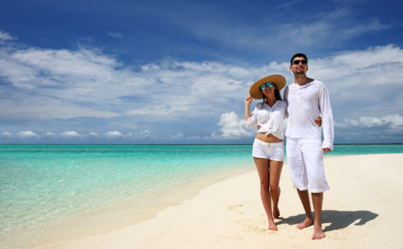 Couple expatrié marchant sur une plage à l’île Maurice, symbole de transition de vie à deux